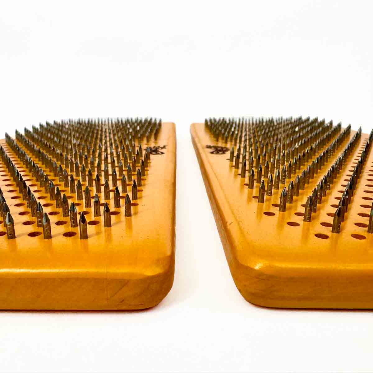 Two wooden yellow boards with nails for yoga on a white background