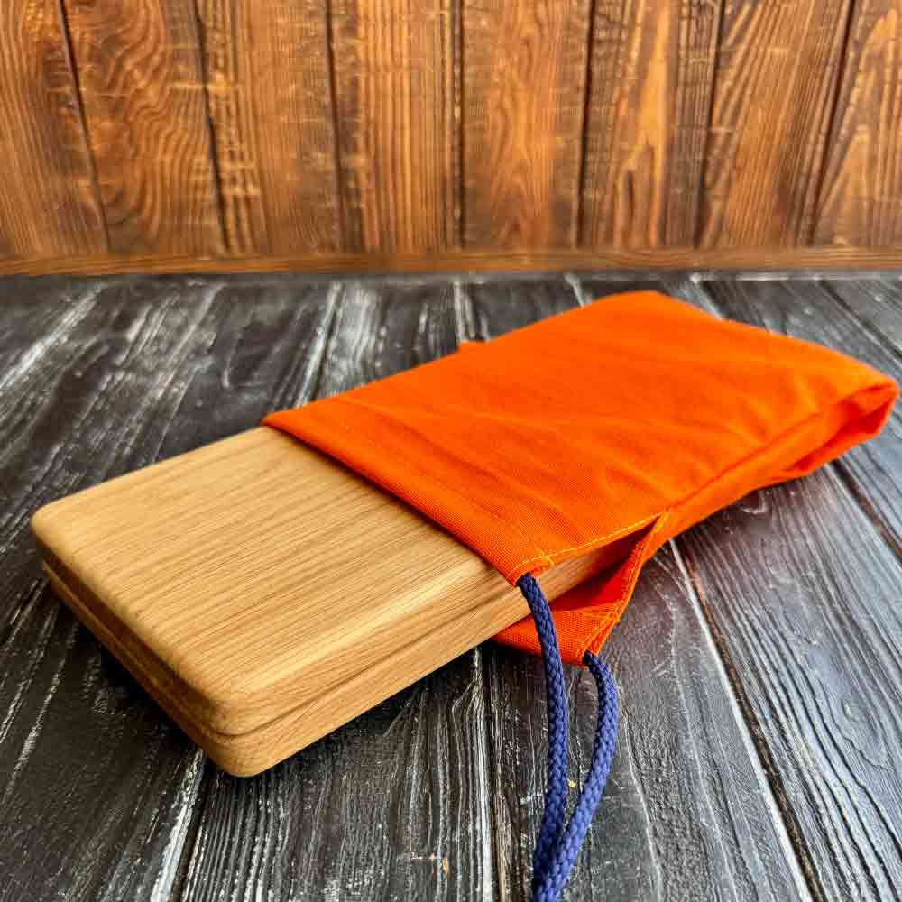 oak wood sadhu board in orange fabric case.