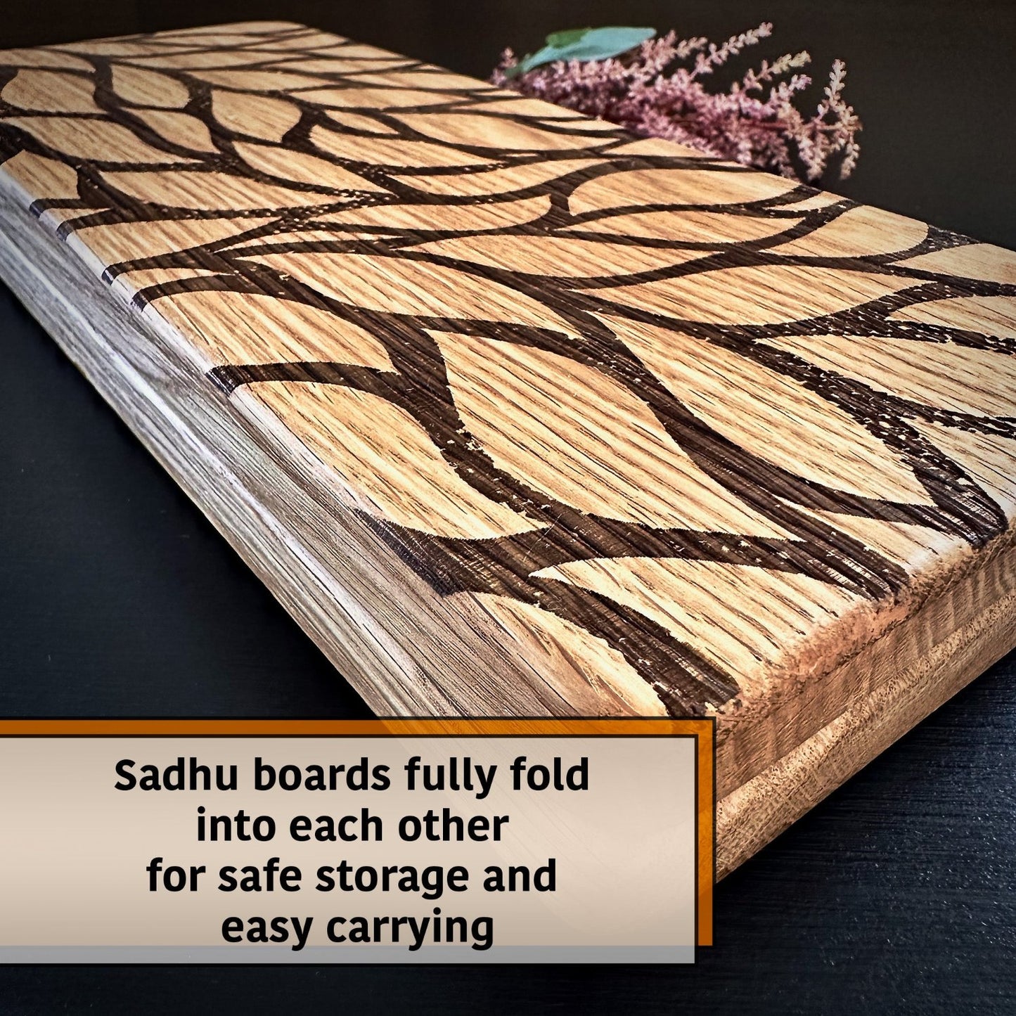 folded sadhu board with leaves engraving, some flower and leaves behind on black background