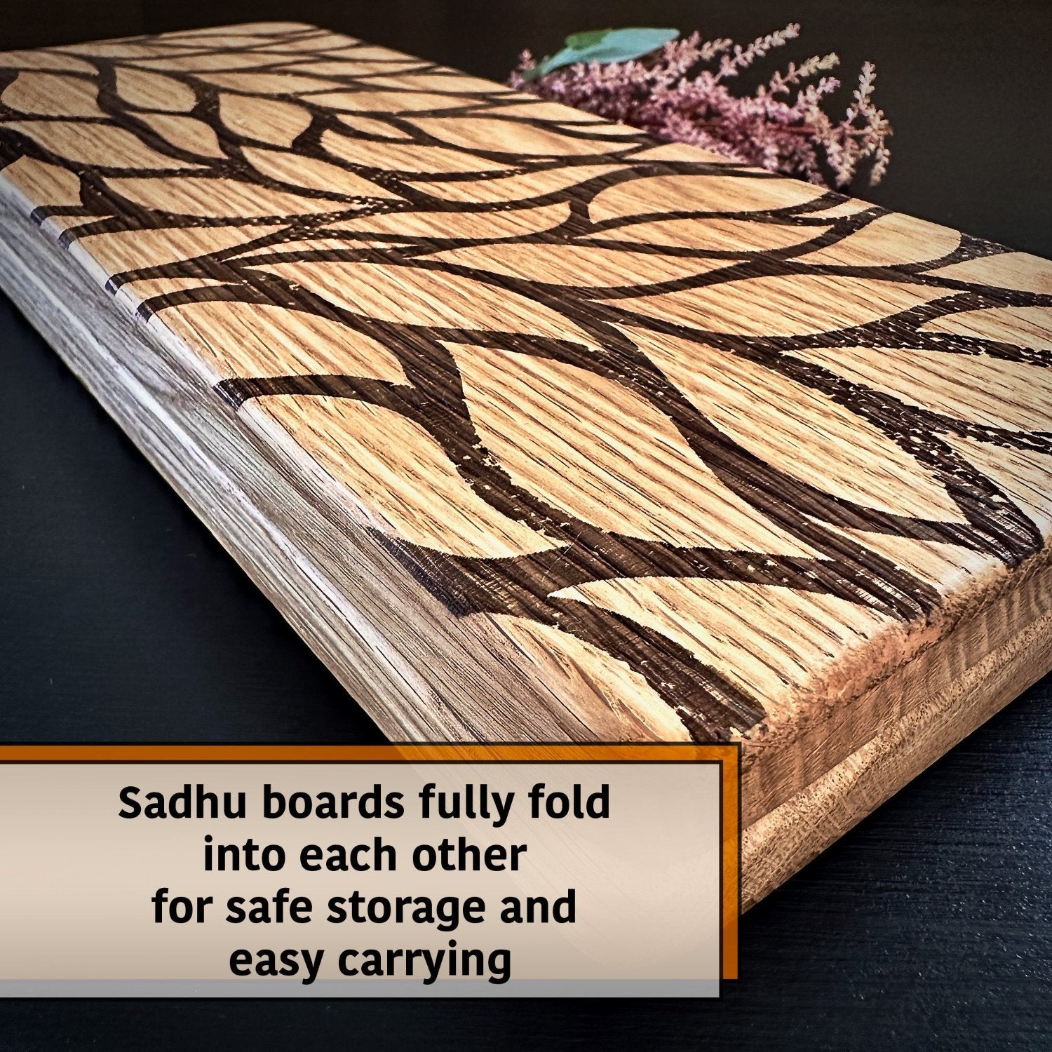 folded sadhu board with leaves engraving, some flower and leaves behind on black background