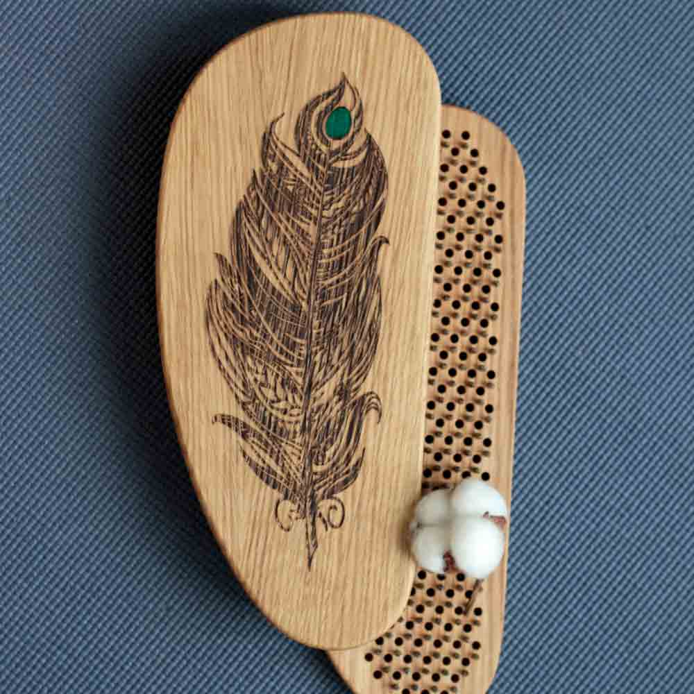 Sadhu board from oak with feather design on a blue textured background