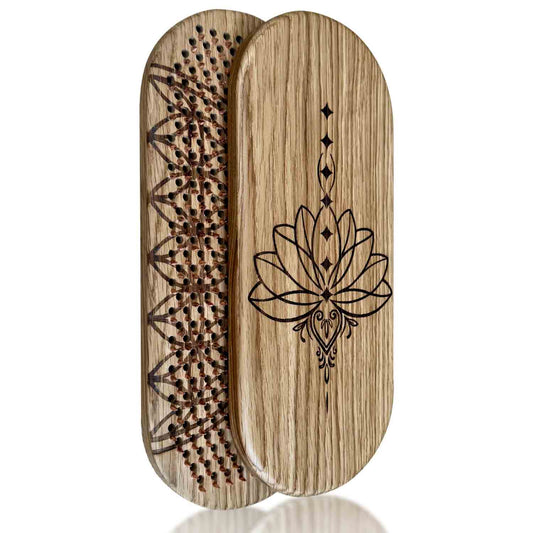 An oak wood sadhu board with copper nails, with engraved lotus flower design on the front and a flower of life engraving inside nails side on a white background.