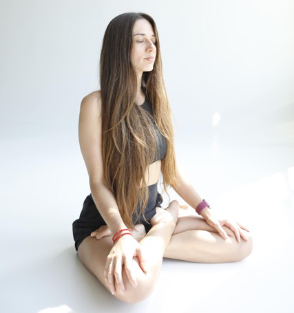 Sadhu board benefits for mind. yoga girls after standing on nails sadhu board is calming in yoga pose in white room. Woman meditating in a serene, white studio setting, demonstrating the tranquility and mindfulness benefits of using a Sadhu board