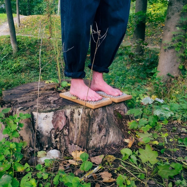 Yogis girl standing on sadhu board on nature