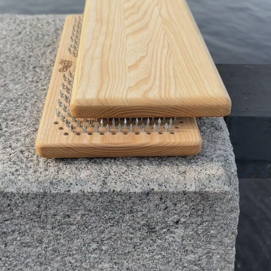 Sadhu board with nails from ash wood placed on rocks near water