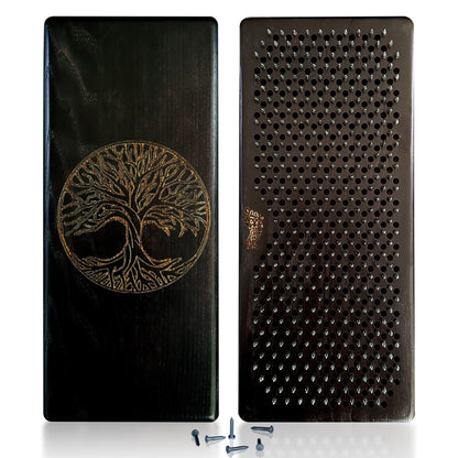 A black Sadhu board with intricate Tree of Life engraving on the front. The board is made from high-quality natural ash wood, colored in a deep black shade. The back of the board features a grid of galvanized nails arranged in a precise pattern, ideal for acupressure. The image also includes a few additional galvanized nails placed beside the board.