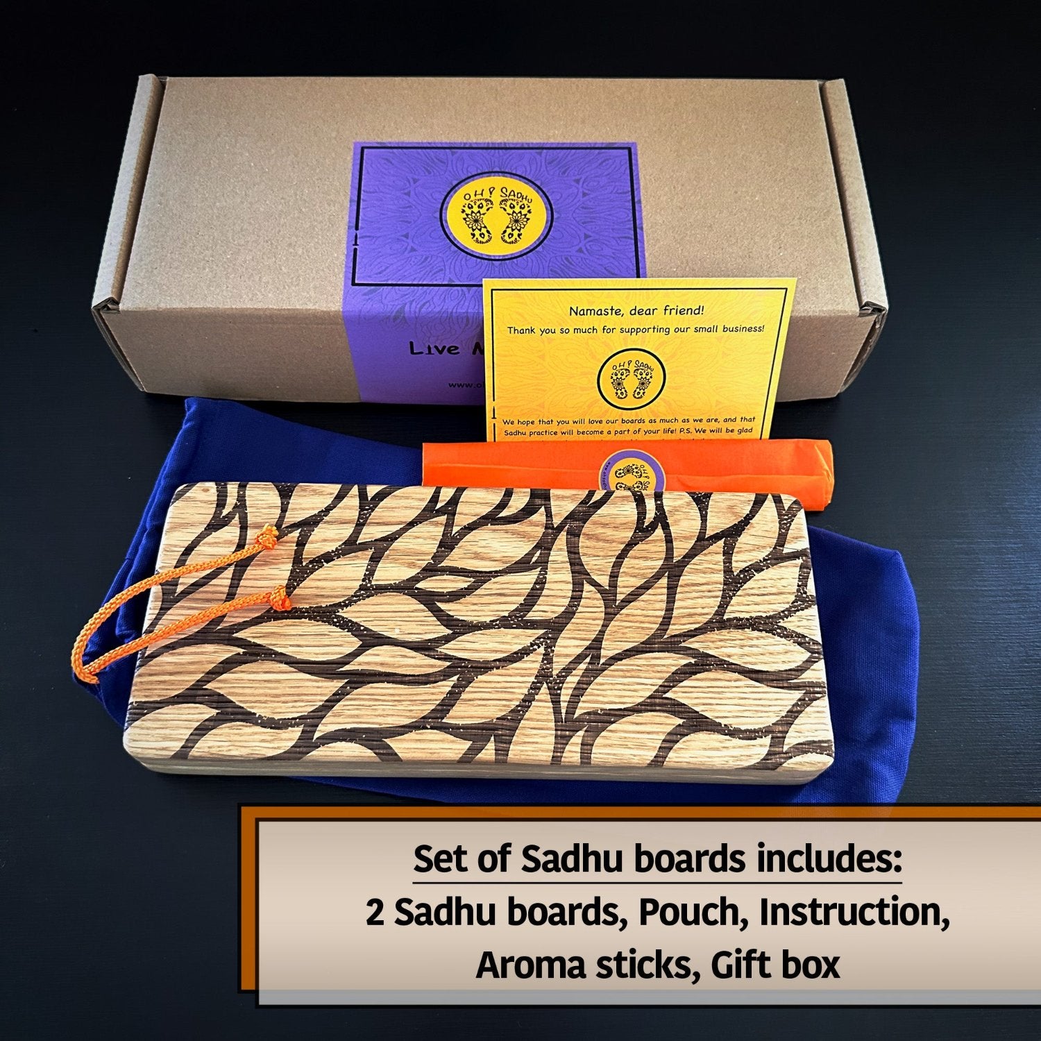 Grey boz with violet sticker with feet on it and Oh! Sadhu brand, yellow instruction, orange pack with aroma stick, sadhu board with leaves engraving, violet pouch