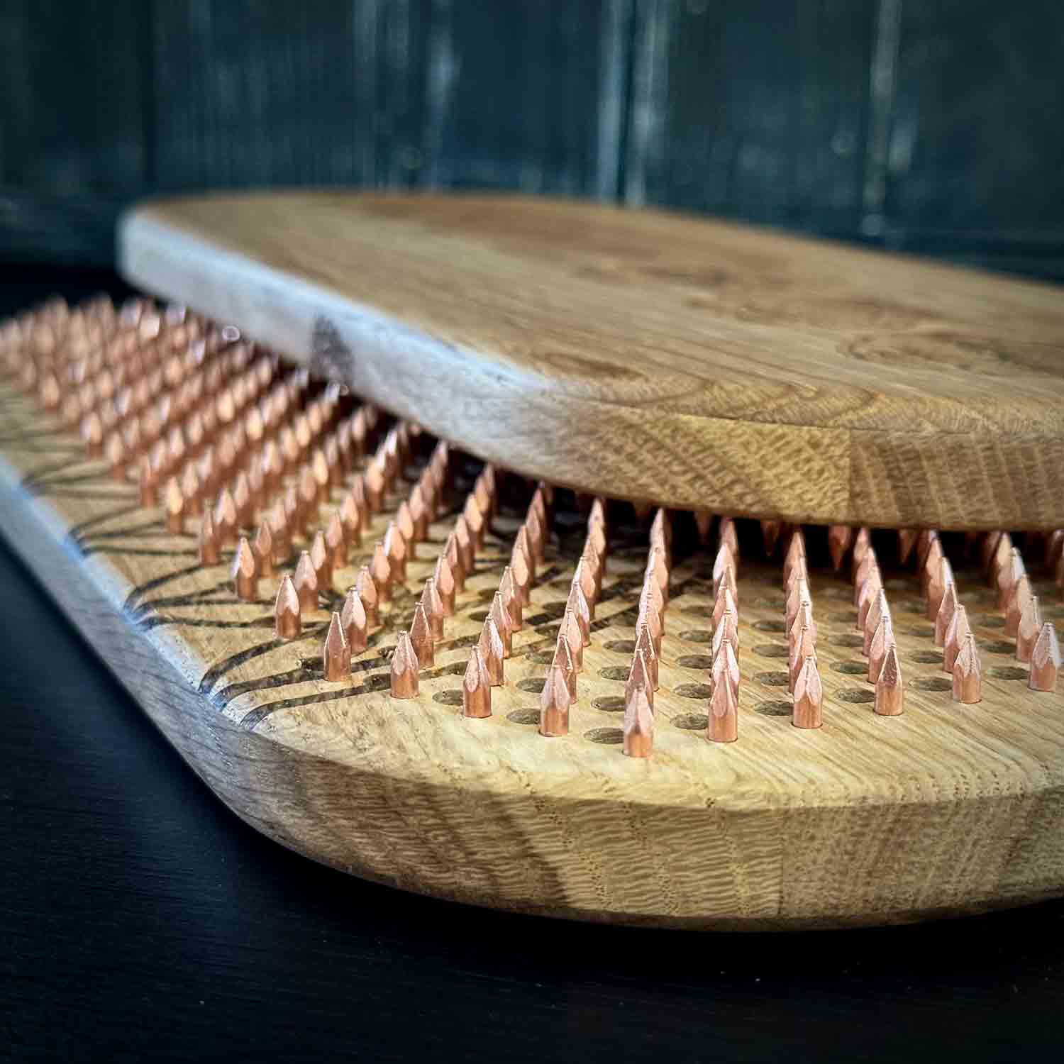 Oak wood sadhu boards with copper nails on a dark background