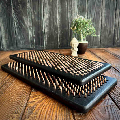 Black nail boards on a wooden surface with a wooden blurred background
