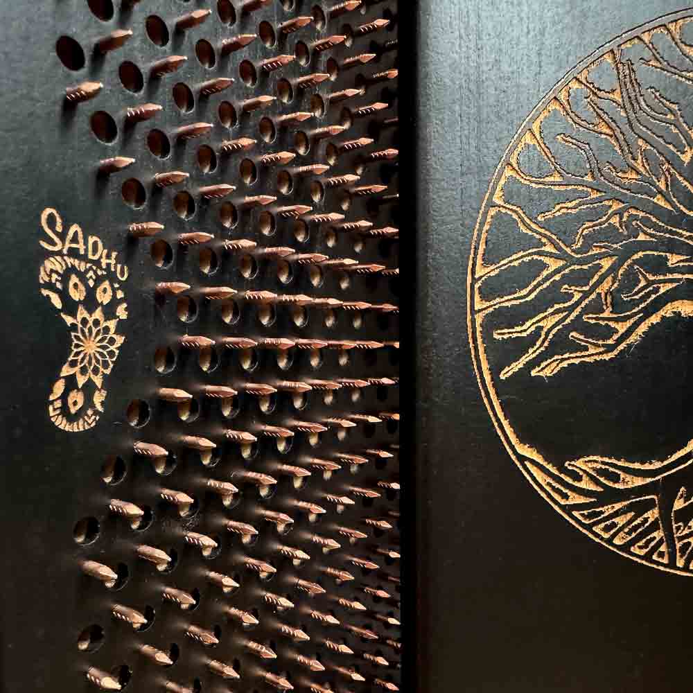 Close-up of a black sadhu boards with copper nails and 'OH! SADHU' branding.