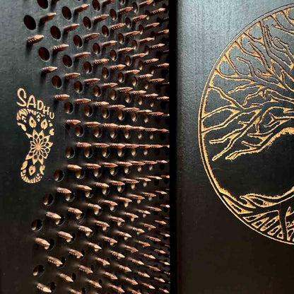 Close-up of a black sadhu boards with copper nails and 'OH! SADHU' branding.