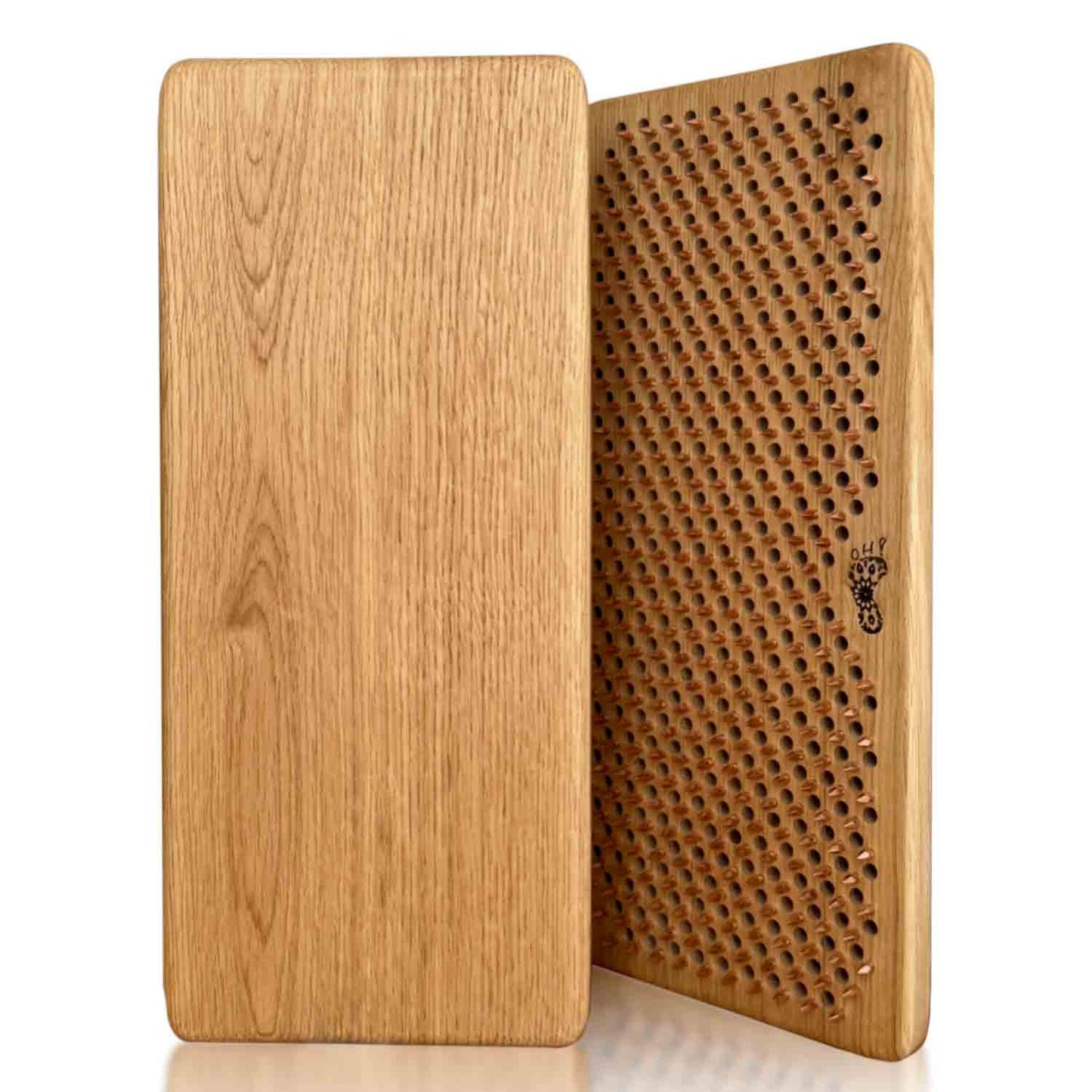 A rectangular oak wood sadhu board with copper nails for feet massage shown from two angles: one side displaying a smooth natural oak wood grain finish, and the other showing a copper nails in pattern Flower of Life. The brand name 'Oh! Sadhu' is printed on the side.