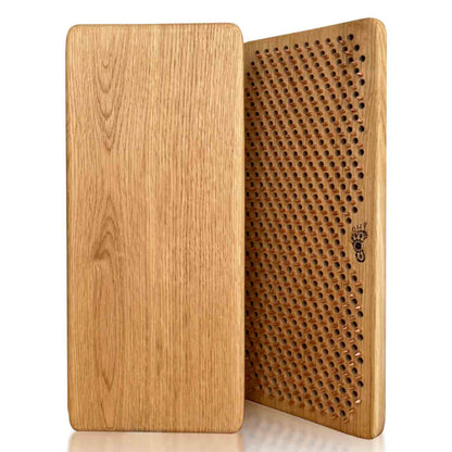 A rectangular oak wood sadhu board with copper nails for feet massage shown from two angles: one side displaying a smooth natural oak wood grain finish, and the other showing a copper nails in pattern Flower of Life. The brand name 'Oh! Sadhu' is printed on the side.