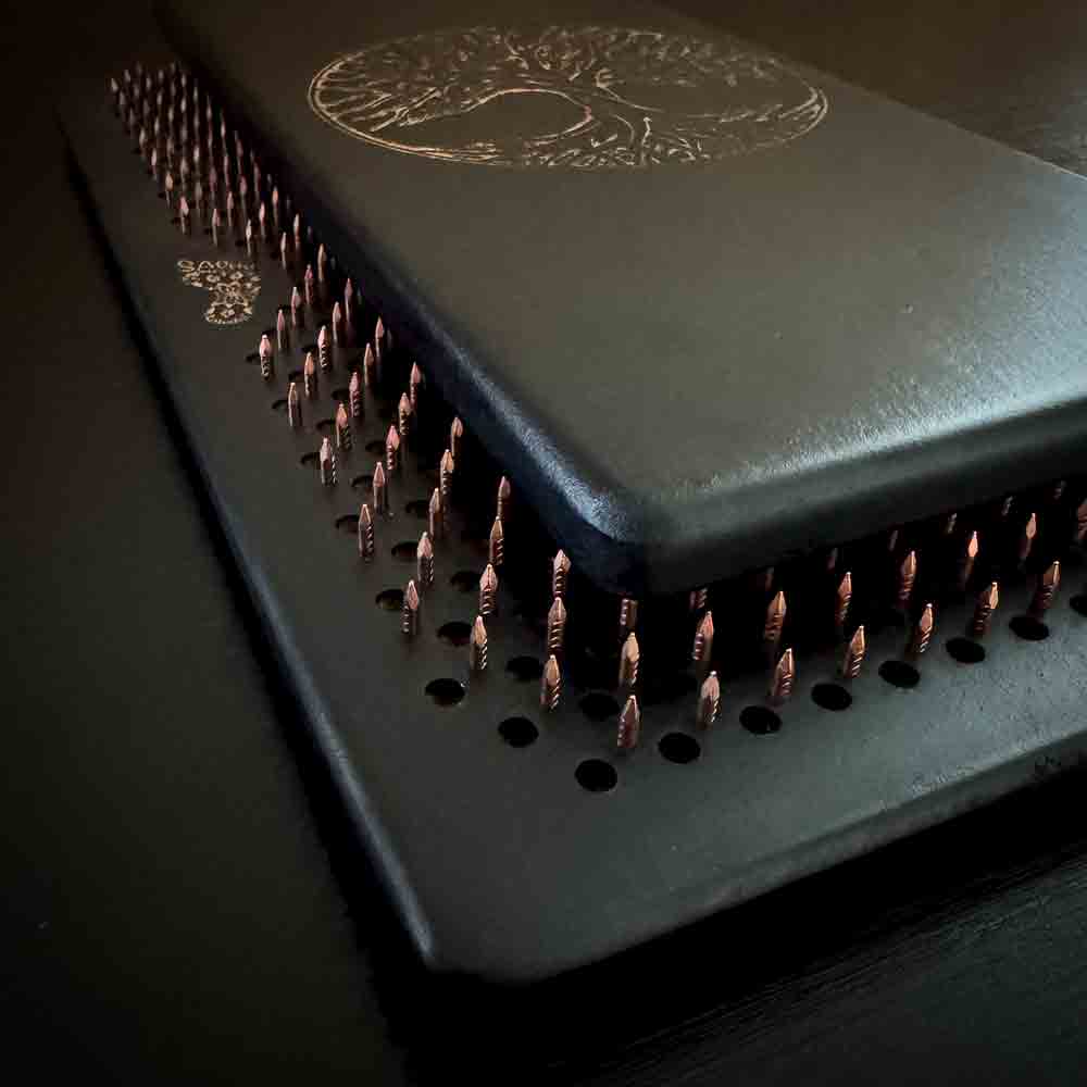 Black sadhu boards with copper nails with engraved Tree of Life design on a dark background