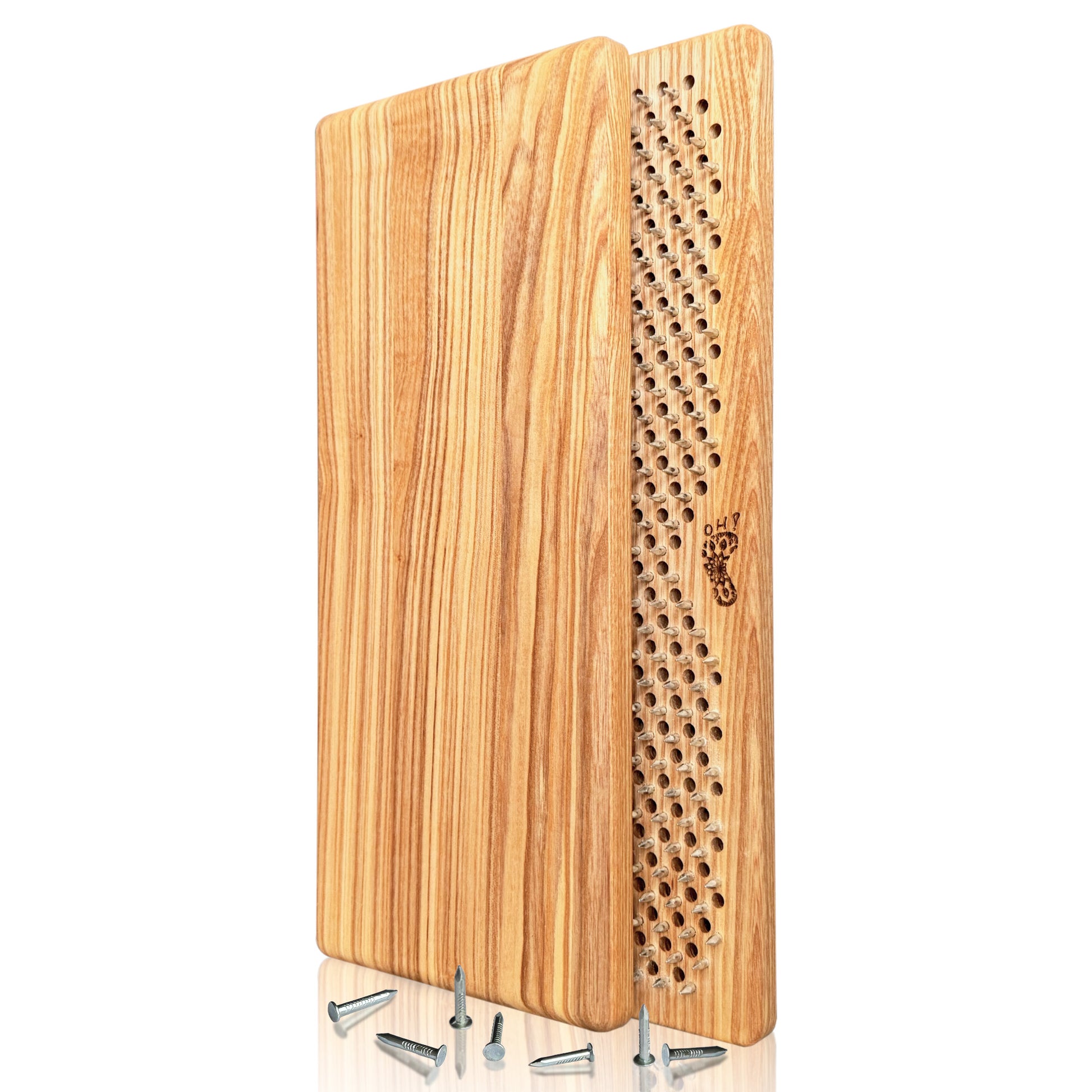 A pair of Sadhu boards made from natural ash wood. The front board features a design of multiple evenly spaced nails in a grid pattern for acupressure, with a small engraved footprint logo. The back board showcases the natural grain of the ash wood, highlighting its light, natural color and smooth texture. Several loose nails are scattered at the base of the sadhu boards.