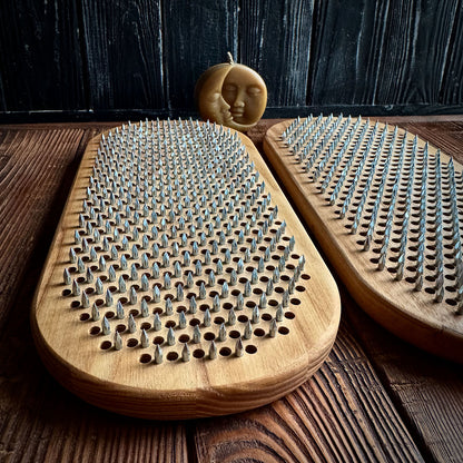 two sadhu boards with nails for feet in wooden floor