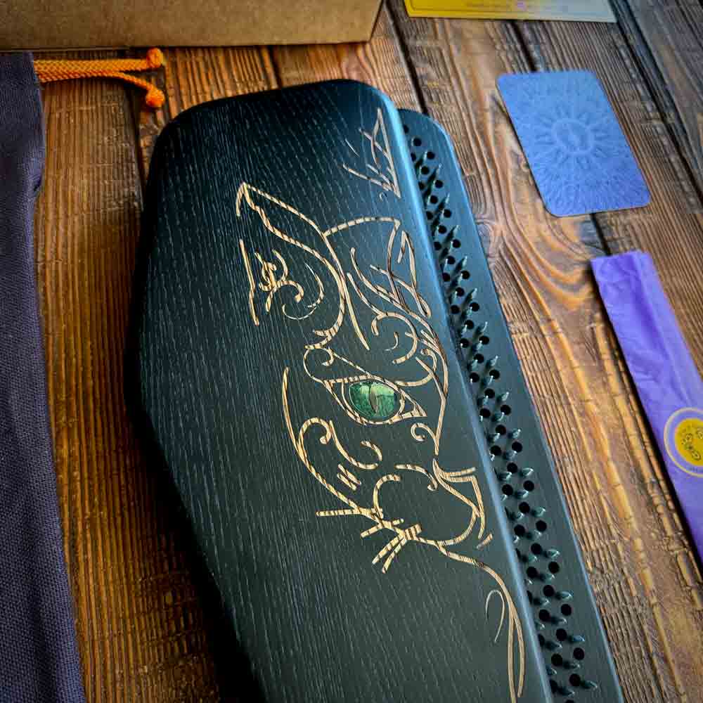 Sadhu nail boards in black color made from ash wood with a cat design on a wooden surface