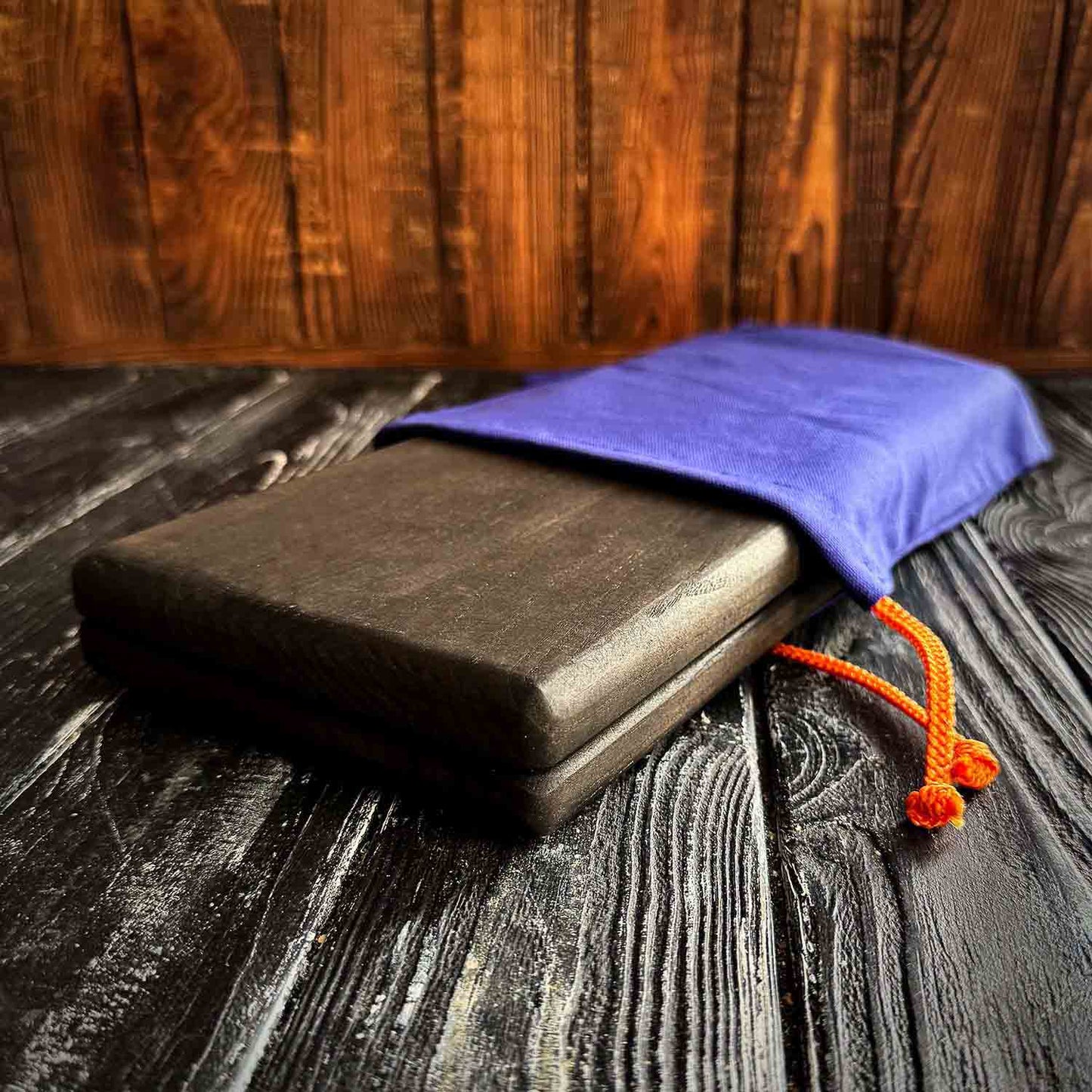folded black sadhu board in blue fabric case with yellow lace