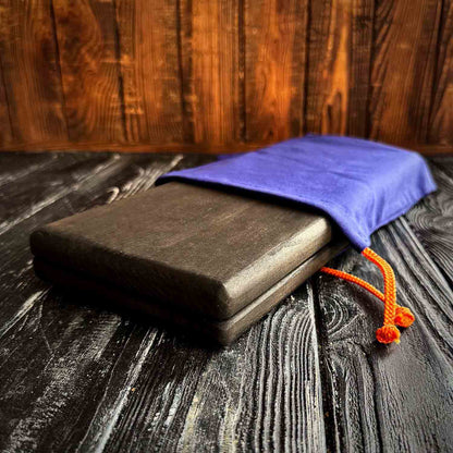 folded black sadhu board in blue fabric case with yellow lace